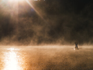 Woman paddling on sup board on Sunrise