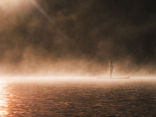 Woman paddling on sup board on Sunrise