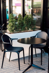 Black chairs and a table in a summer cafe outside. Lunch, rest