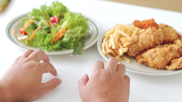 Close up hand of fat man hesitate to eat between healthy food and junk food