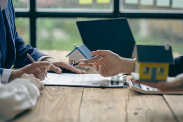 Fototapeta premium Home agents talk to new homebuyers and offer good interest rates and calculate clients on mortgage financing to help them decide on real estate ideas with insurance.