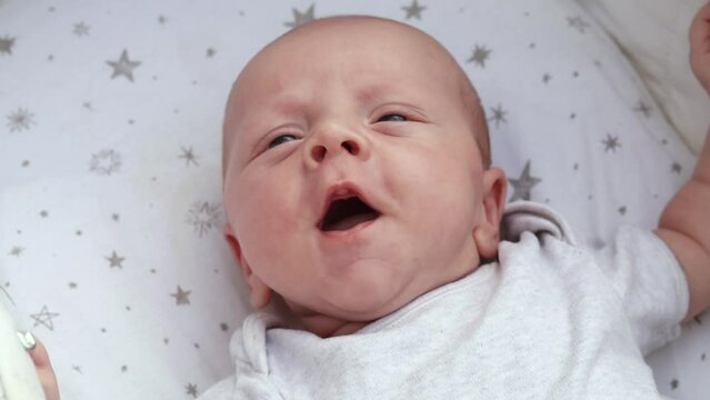 1080p slow motion footage video. Close up newborn baby child lying in baby carriage stroller buggy having fun playing, looking at her mother, smiling infant. Outside walking in pushchair, fresh air
