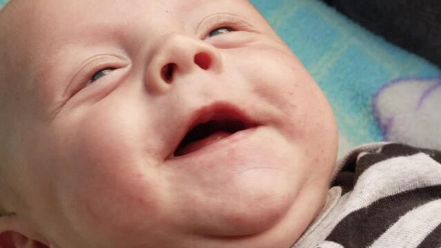 4k footage video. Close up newborn baby child lying in baby carriage stroller buggy having fun playing, looking at her mother, smiling infant. Outside walking in pushchair, fresh air
