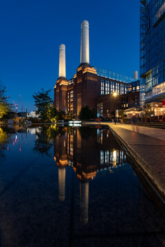 Battersea Power Station following a 10 year complete renovation, shot at blue hour reflected in water, and ready to open as the UK's largest Shopping Mall end of 2022