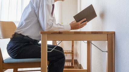 前屈みで本を読む姿勢の悪いビジネスマン