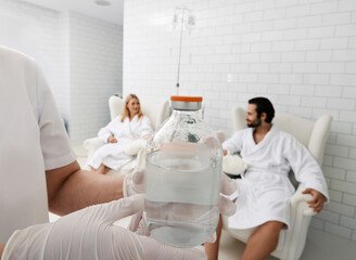 Jar with vitamin cocktail for intravenous therapy in hands of healthcare worker for wellness center...