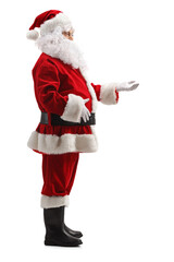 Full length profile shot of santa claus standing and waiting with arm forward