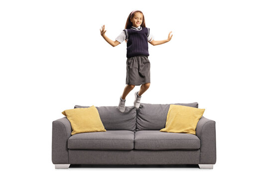 Schoolgirl In A Uniform Jumping On Sofa