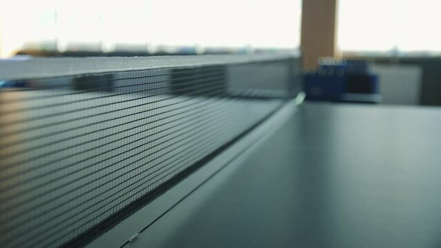 Table with mesh for ping pong game in empty hallway close view. Equipment for sports game and recreation in office