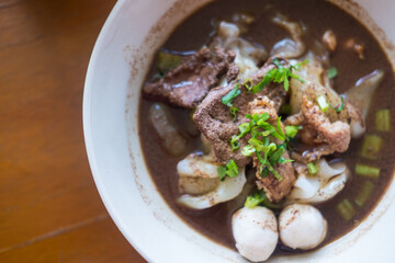 Close up of a bowl Thai style beef noodle soup. Selective focus