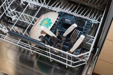 Dirty dish and cutlery in the dishwasher.