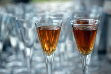 Golden colored alcoholic short drinks in shot glasses. Illustration photo of celebration or fun lifestyle.