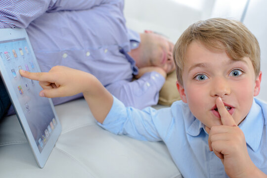 A Sneaky Child Using A Tablet