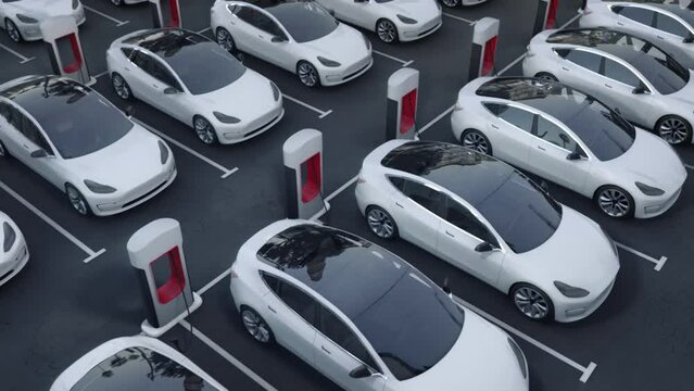 
Parking Lot With Electric Charging Stations For Driverless Vehicles. Holographic Animated Connections. IOT. Aerial View of New Generic Modern EV Self Driving Cars. 