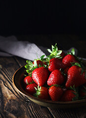 A bowl with ripe bright strawberry in rustic style