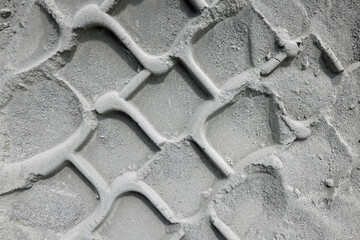 Trace of a car or tractor tire track in the dust sand. Abstract illustration photo of transportation or hard weather traffic conditions.