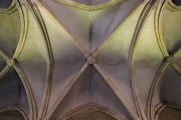 Symmetrical arches of a gothic vault of Vajdahunyad (Hunedoara) castle in Transylvania, Romania. Color abstract interior architectural photo.