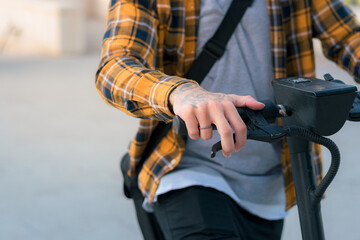 Close-up of a man riding an electric scooter on a street