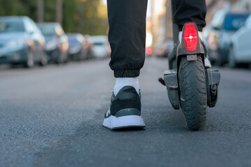 Close-up of a man riding an electric scooter on a street. Ground view © Cristian Blázquez