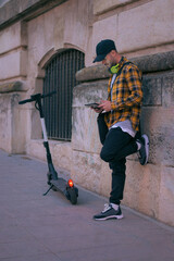 Man with a electric scooter works remotely with tablet at night © Cristian Blázquez