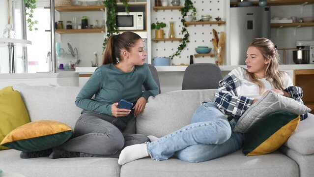 Young lesbian couple at home have a problem and argue due to jealousy caused by chatting and flirting via social media networks on smart phones, relationship difficulties problems and distrust