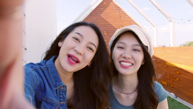 POV of young asian woman with friend holding phone  selfie making video call