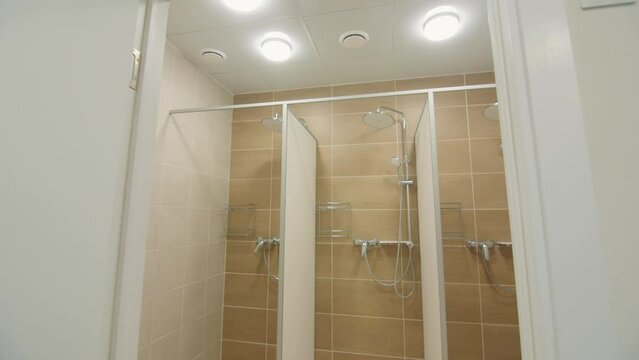 Separated shower cabins with new equipment in washing room of sports club. Personal hygiene conveniences for sportsmen