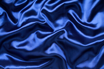 Close-up abstract texture midnight blue color fabric cloth textile background, silk wavy material, satin waves, soft folds waves on the fabric. Macro, web theme, template, wallpaper, concept design