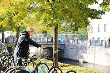 young man walking in the park, riding a bicycle on a warm sunny autumn day