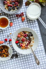 Oatmeal with raisins and frozen berries on a dining table with a checkered napkin.