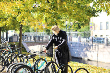 young man walking in the park, riding a bicycle on a warm sunny autumn day