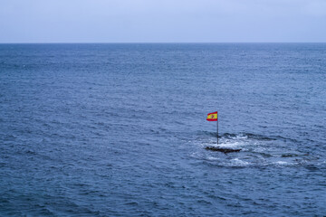 Spanish flag standing in the middle of the Atlantic Ocean, Gran Canaria