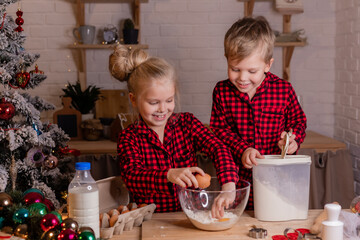 happy children bake Christmas cookies at home in the kitchen