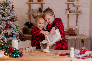 happy children bake Christmas cookies at home in the kitchen