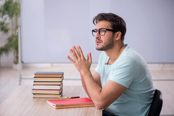 Young male student preparing for exams in the classroom