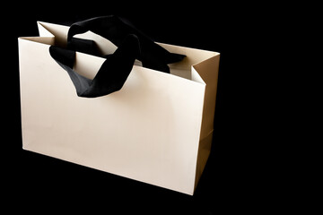 Shopping cardboard bag on black background with space to write. Black friday sale concept.