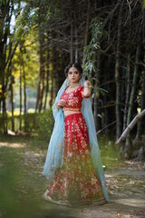 beautiful girl wearing red dress posing in park