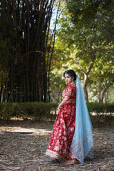 beautiful girl wearing red dress posing in park