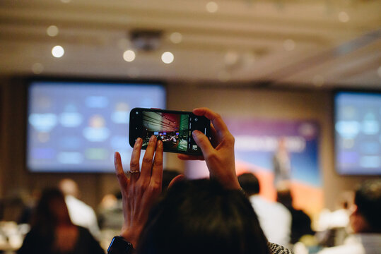 Speaker giving a take photo in conference hall at business event. Audience at the conference hall. Business and Entrepreneurship concept. Focus on unrecognizable people in audience.