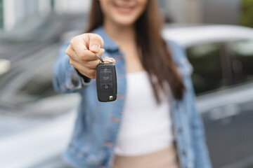 transportation rental automotive business concept. Close up hands of rental auto agent giving car remote key to client to travel sightseeing. - obrazy, fototapety, plakaty