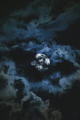 Night sky with full bright moon in the clouds