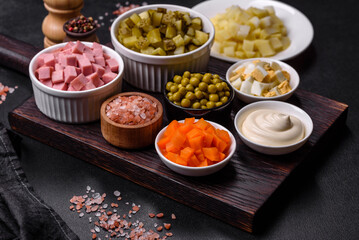 Delicious fresh Olivier salad with sausage, egg, cucumber, green peas, carrots and mayonnaise