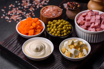 Delicious fresh Olivier salad with sausage, egg, cucumber, green peas, carrots and mayonnaise