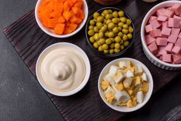 Delicious fresh Olivier salad with sausage, egg, cucumber, green peas, carrots and mayonnaise
