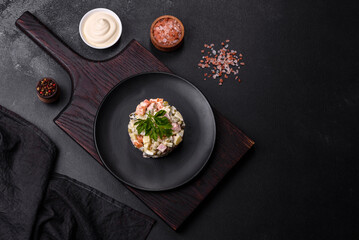 Delicious fresh Olivier salad with sausage, egg, cucumber, green peas, carrots and mayonnaise