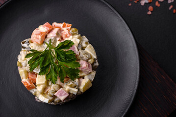 Delicious fresh Olivier salad with sausage, egg, cucumber, green peas, carrots and mayonnaise