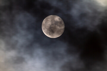 Fototapeta na wymiar Full Moon at Night with Passing Clouds