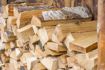 Birch firewood stacked in a woodpile for heating the stove.
