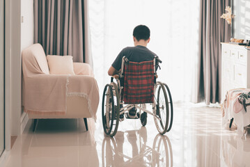 Young man with disability have some things to think about that can lead to depression,Teenager boy sitting alone in living room with sunlight, Sad emotional or loneliness and mental health concept.