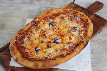 Cinque Formaggi crispy stone fried pizza served in a cutting board isolated on grey background side view